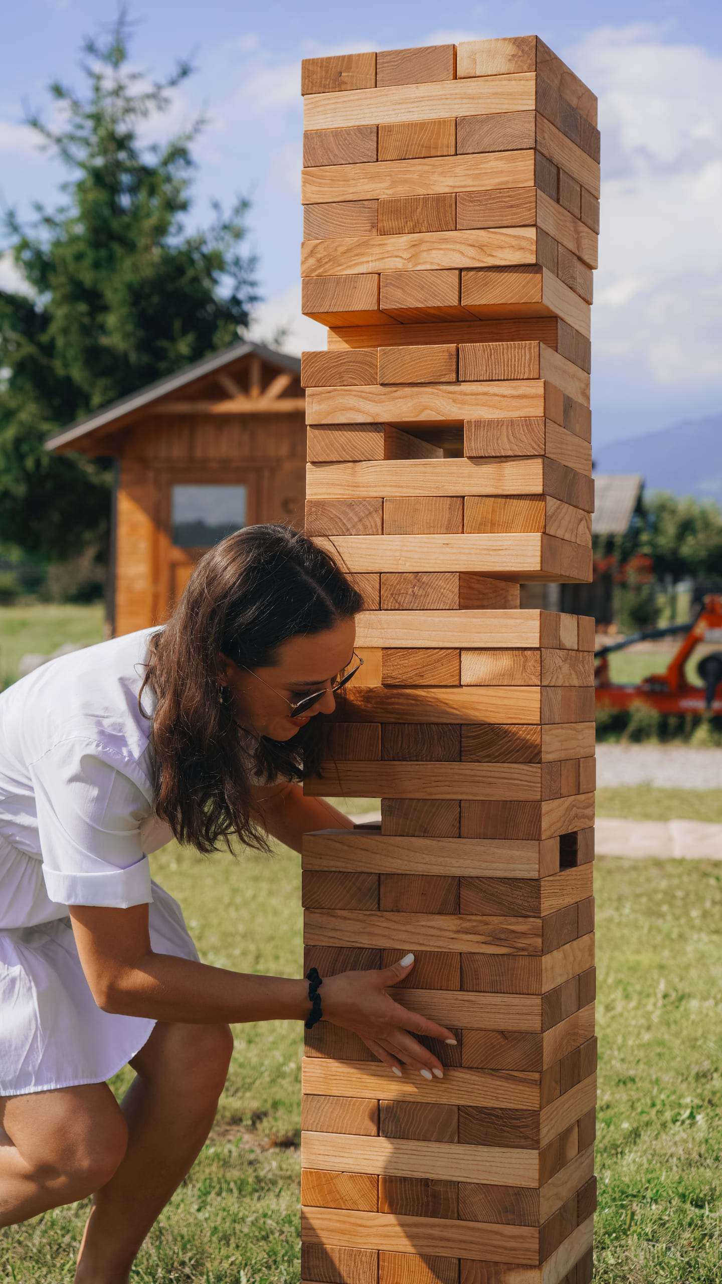 Igralka pogleda skozi vrzel v Jenga stolpu