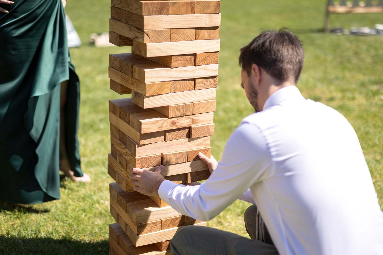 Svat izvleče blok iz Jenga stolpa med poročno zabavo
